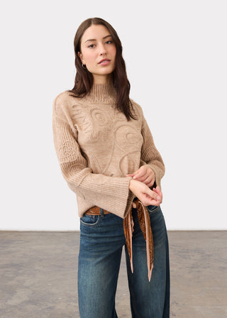 Woman wearing a brown sweater and jeans