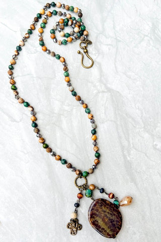 Beaded necklace with a pendant on a textured white surface