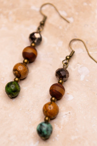 Pair of beaded earrings on a textured beige background