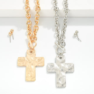 Two cross necklaces, one gold and one silver, on a white background.