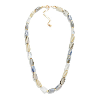 A beaded necklace featuring faceted beads in shades of gray, cream, and white, separated by small gold spacers, with a gold chain extender clasp.