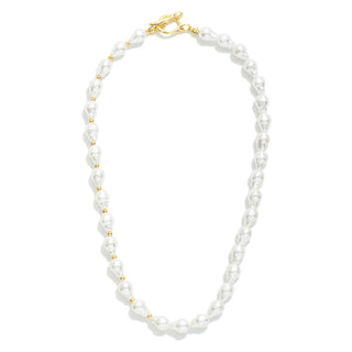A beaded necklace featuring irregular white baroque pearls separated by small gold spacer beads, finished with a gold clasp, shown on a solid white background.
