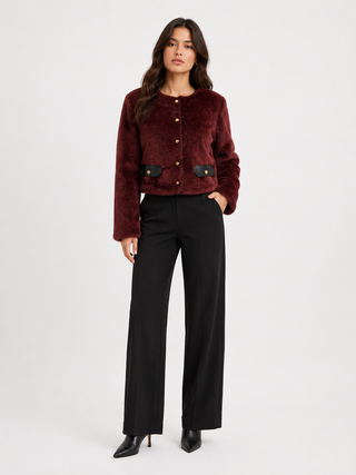 Woman modeling a burgundy colored coat and black slacks