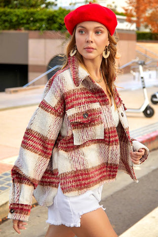 Woman wearing a red and white plaid jacket with a red beret outdoors.