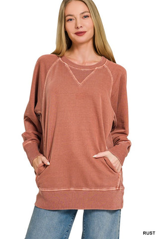 Woman wearing a rust-colored sweatshirt with a plain background