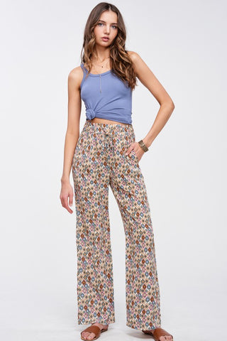 Woman wearing a blue top and floral pants on a white background