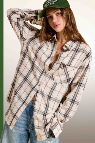 Woman wearing a plaid shirt and jeans with a green cap on a white background
