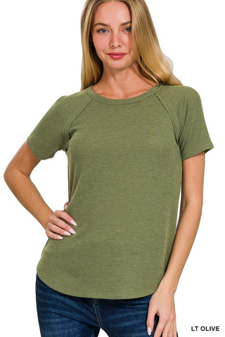 Woman wearing a light olive green t-shirt on a white background