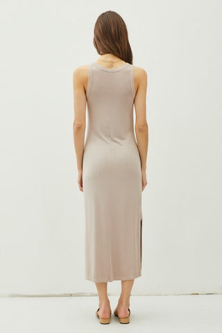 Woman wearing a beige sleeveless dress against a white background