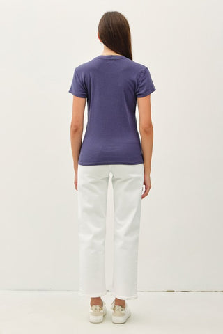 Person wearing an indigo t-shirt and white pants on a white background