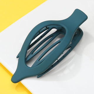 Teal hair clip on a white and yellow background