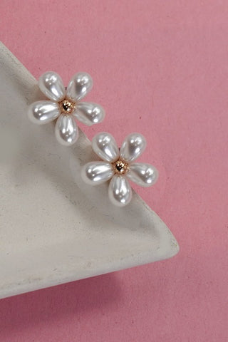 Pearl flower earrings on a pink background