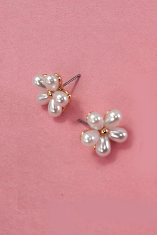 Pearl flower-shaped earrings on a pink background