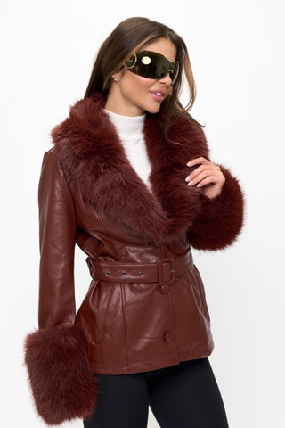 Woman wearing a brown leather coat with fur trim on a white background