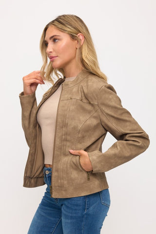 Woman wearing a brown jacket and blue jeans on a white background