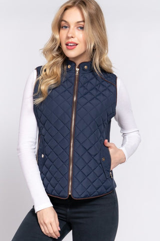 Woman wearing a navy quilted vest on a white background