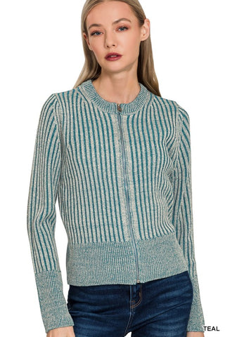 A woman wearing a teal and off-white vertically striped knit zip-up cardigan sweater with blue jeans, shown against a plain white background.