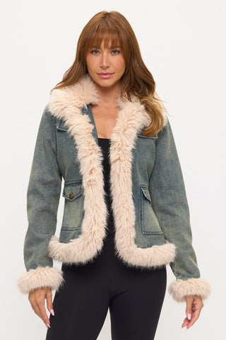 Woman wearing a denim jacket with fur trim on a white background