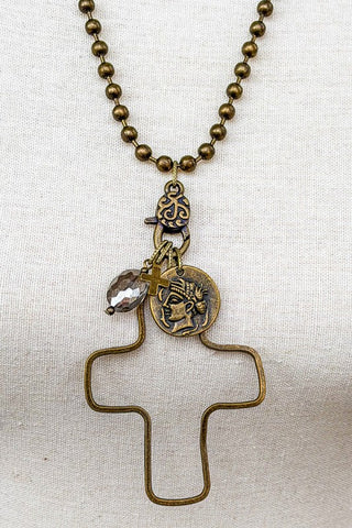 Necklace with cross pendant and decorative elements on a white fabric background