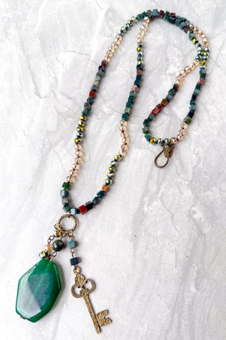 Necklace with colorful beads and a green agate pendant on a white background