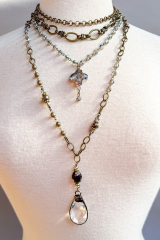 Necklace with multiple chains and beads on a mannequin bust.
