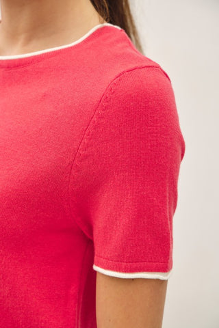 Arm of a woman wearing a red top