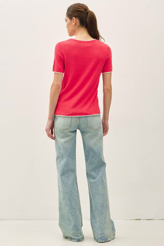 Back of a woman wearing a red sweater and jeans