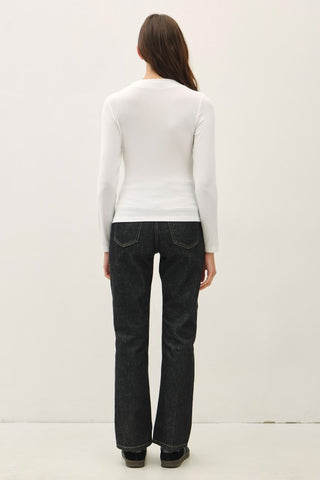 Back of a woman wearing a white shirt and black pants