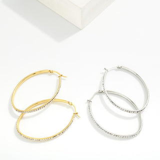 Two pairs of hoop earrings, one gold and one silver, on a white background.