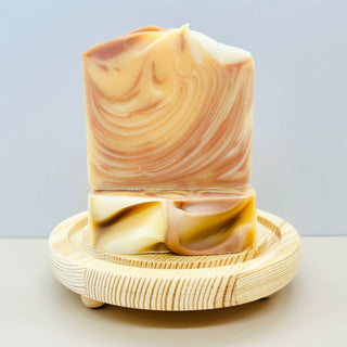 Marbled soap bar on a wooden stand with a light gray background