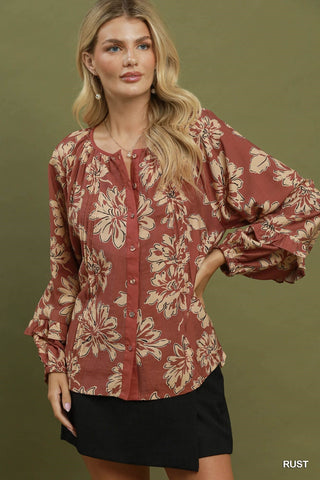 Woman wearing a rust colored floral button down blouse