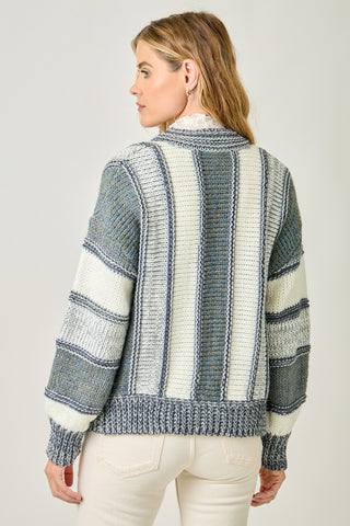 Woman wearing a striped sweater with a neutral background