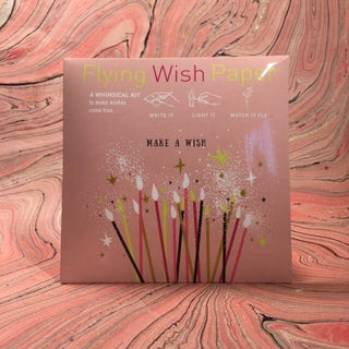 Packaging of Flying Wish Paper on a pink marbled background