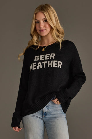 Woman wearing a black sweater with 'BEER WEATHER' text against a gray background