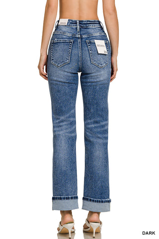 Dark blue jeans worn by a person on a white background