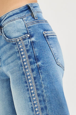 Close-up of blue jeans with star pattern on a white background