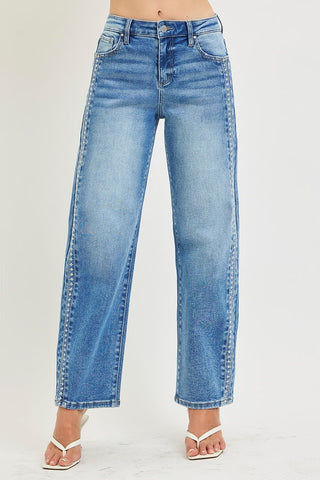 Blue jeans worn by a person on a plain background
