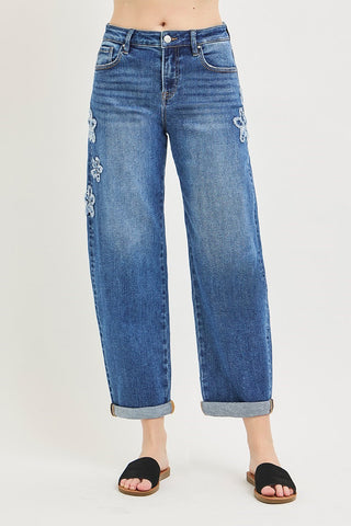 Blue jeans with floral embroidery on a white background
