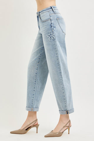 Light blue jeans with floral embroidery on a white background