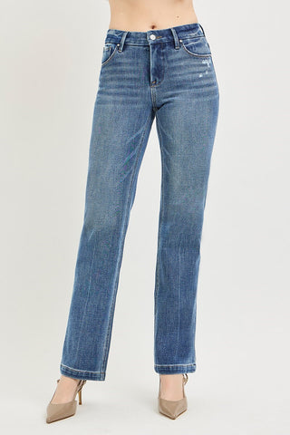 Blue jeans worn by a person on a plain background