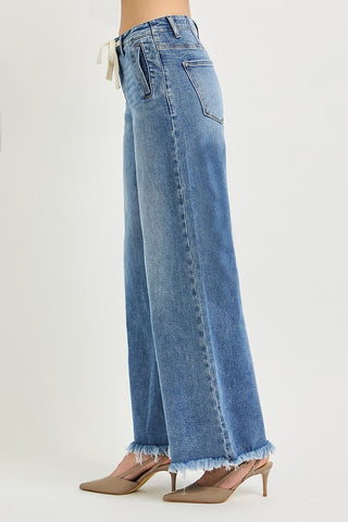 Blue jeans with a frayed hem on a white background