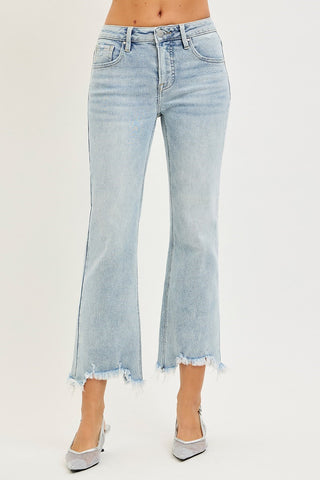 Light wash blue cropped flare jeans with frayed hems, shown on a model wearing silver pointed-toe heels against a plain light background.