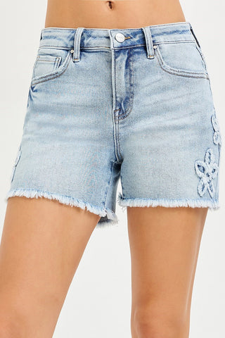 Light blue denim shorts with floral embroidery on a white background