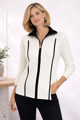 Woman wearing a white zip-up sweater with black accents on a white background