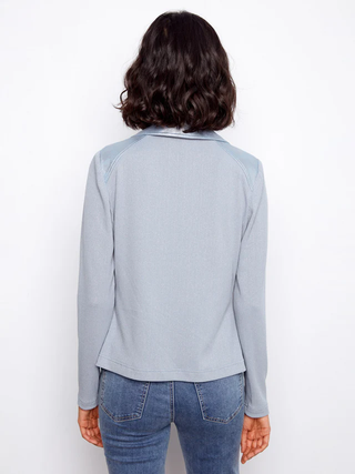 Person wearing a light blue long-sleeve shirt and jeans on a white background