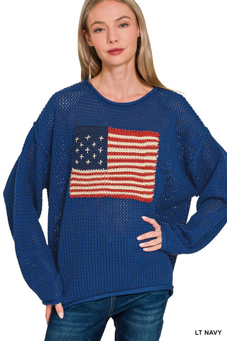 Woman wearing a blue sweater with an American flag design on a white background