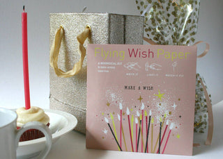 Product packaging with a pink card labeled 'Flying Wish Paper' on a white surface.