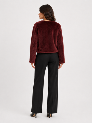 Back of a woman wearing a burgundy colored jacket and black slacks