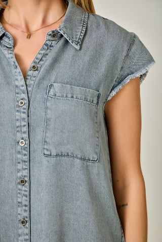 Light blue denim sleeveless shirt worn by a person on a neutral background