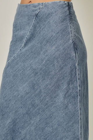 Close-up of a blue denim skirt on a neutral background